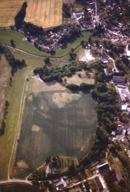 Bild: Der vor 1840 verfüllte Graben und der baumbestandene mittlere Wall treten im Luftbild deutlich hervor (Aufnahme: O. Braasch, 1992)